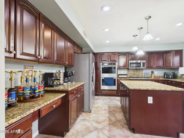 a kitchen with stainless steel appliances granite countertop wooden cabinets a refrigerator and stove