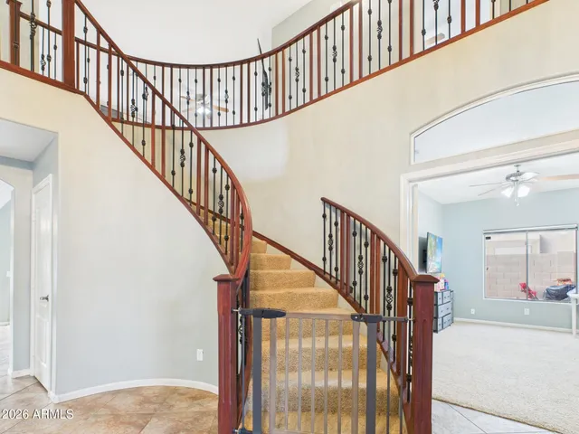 a view of staircase with lots of frames on wall and a window