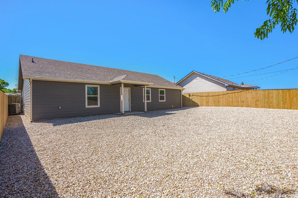 405 North Cleburne Whitney Road Rio Vista, TX 76093 - Photo 23 of 23 Exterior featuring dark gray horizontal siding, a light gray asphalt shingle roof, white trim accents, and a full wood privacy fence