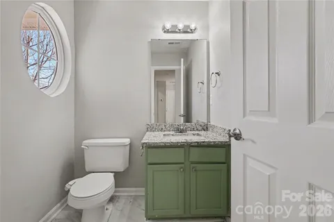 a bathroom with a toilet sink vanity and mirror