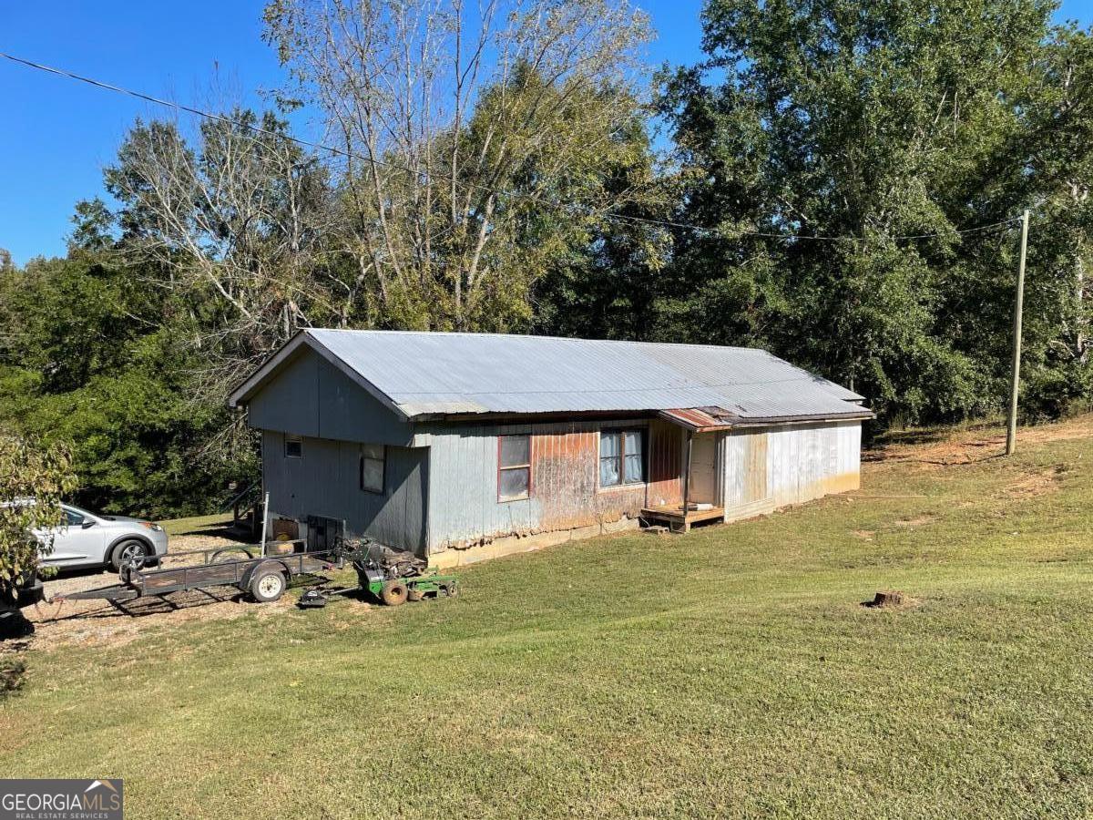 a view of a house with a yard and sitting area