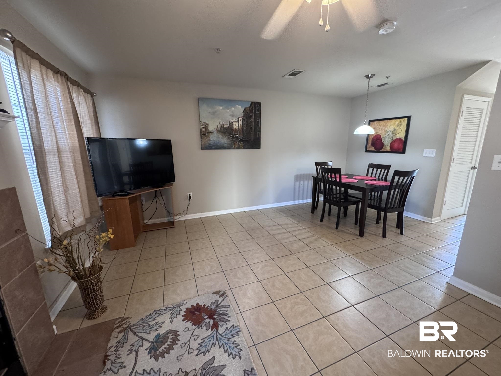 1517 Regency Road, Unit 131 Gulf Shores, AL 36542 - Photo 6 of 21 Dining area featuring light tile patterned floors, a ceiling fan, and vaulted ceiling