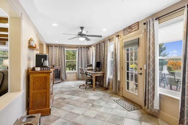 a living room with furniture a dining table and a refrigerator