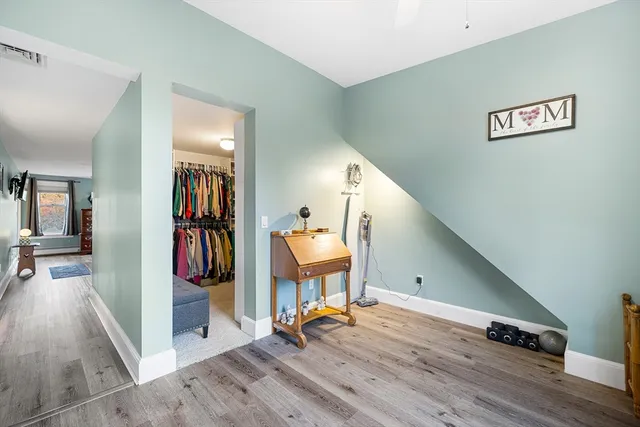 a view of a hallway with wooden floor and windows