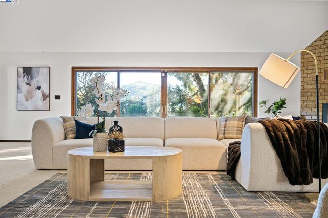 a living room with large window and a table
