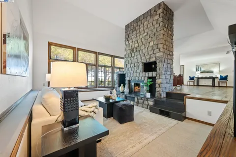 a living room with furniture a fireplace and a large window