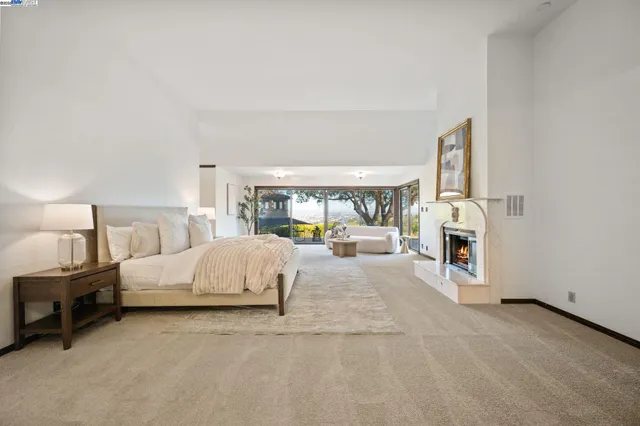 a spacious bedroom with a large bed and a fireplace