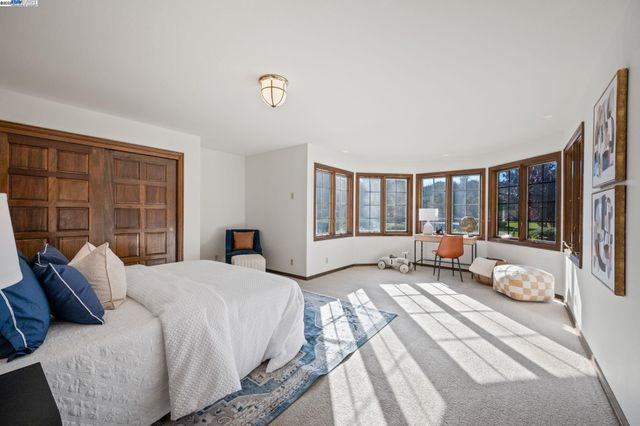 a spacious bedroom with a bed and wooden floor