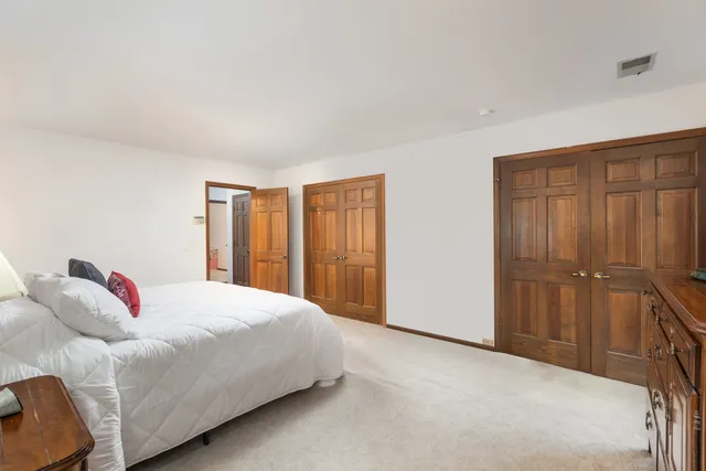 a spacious bathroom with a double vanity sink a toilet and a mirror