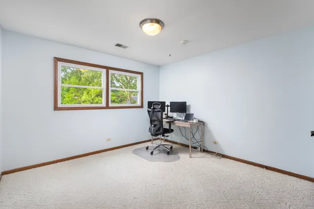 a view of a workspace with furniture and a window
