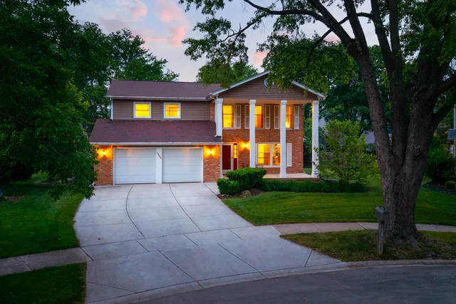a front view of a house with a yard and trees