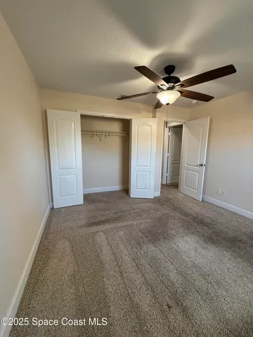 a view of a big room with a ceiling fan