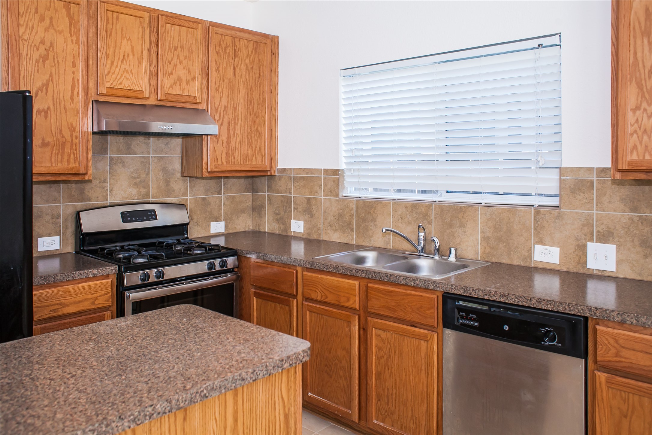 7015 Rancho Mission Drive Houston, TX 77083 - Photo 12 of 21 a kitchen with stainless steel appliances granite countertop a sink stove and cabinets