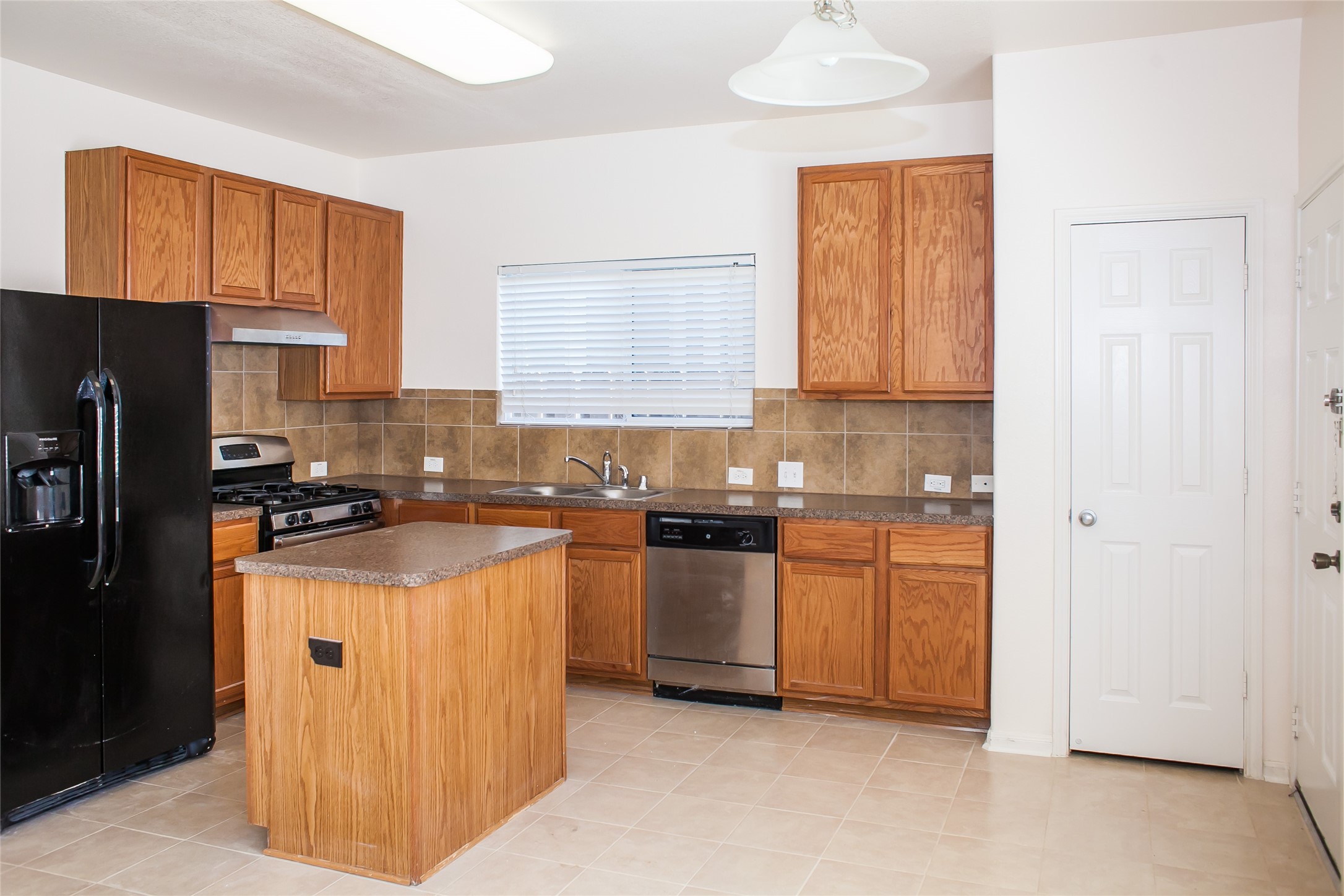 7015 Rancho Mission Drive Houston, TX 77083 - Photo 9 of 21 a kitchen with stainless steel appliances granite countertop a stove top oven a refrigerator a sink and dishwasher with white cabinets