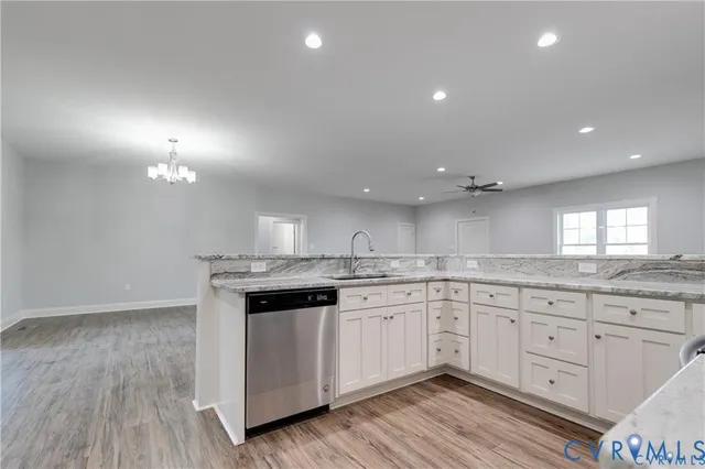 a kitchen with granite countertop white cabinets and white appliances