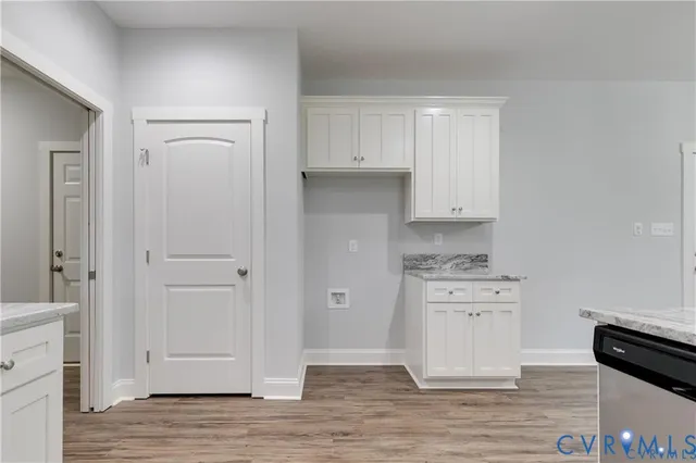 a kitchen with granite countertop white cabinets and white appliances