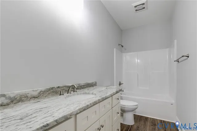 an empty room with chandelier fan and windows