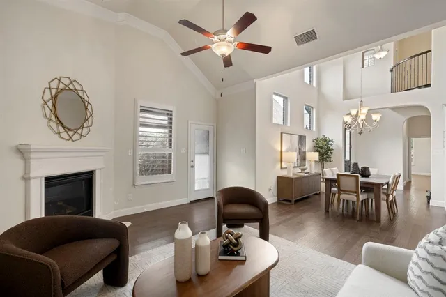 a living room with furniture a fireplace and a chandelier