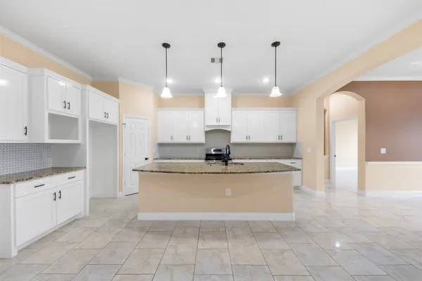 a large kitchen with kitchen island a sink a counter space and stainless steel appliances