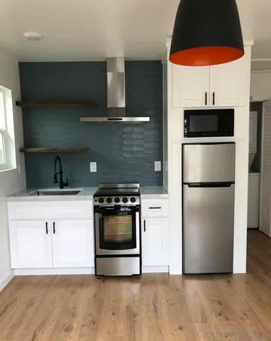 a kitchen with a sink a microwave a stove and refrigerator