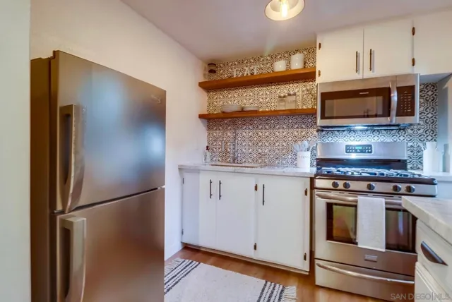 a kitchen with stainless steel appliances granite countertop a refrigerator stove and microwave