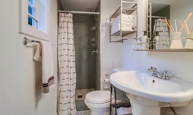 a bathroom with a sink a toilet and shower