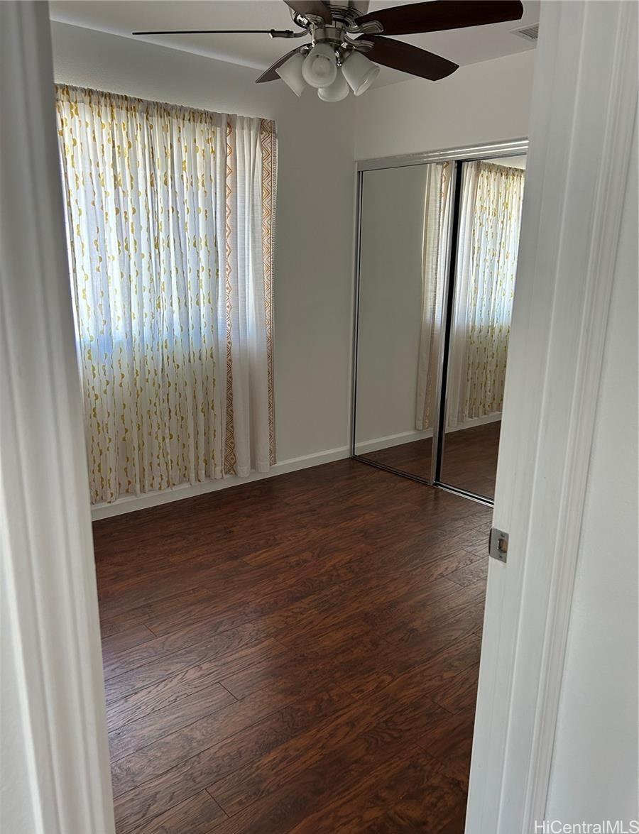 91-1179 Kaimalie Street Ewa Beach, HI 96706 - Photo 11 of 16 a view of an empty room with wooden floor and a window