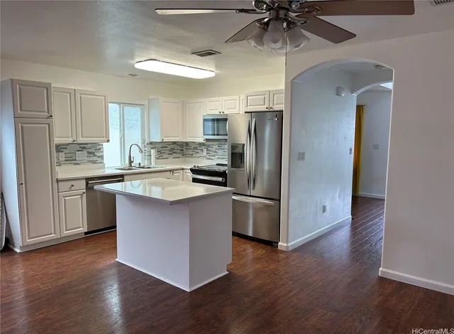 a kitchen with stainless steel appliances a refrigerator a stove a sink and a hard wood floors