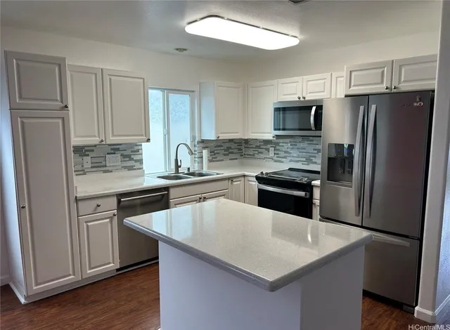 a kitchen with a refrigerator a sink a stove and cabinets