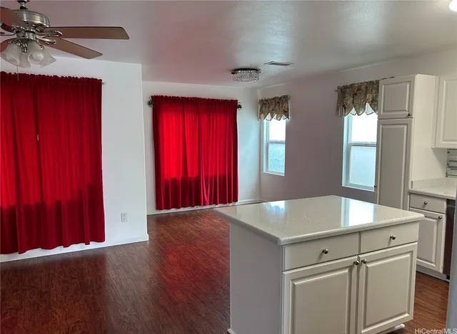 a view of a kitchen with a refrigerator and wooden floor