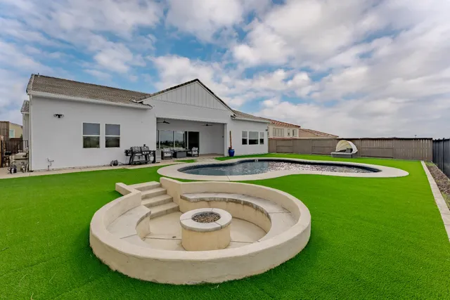 a view of a house with a swimming pool and a yard