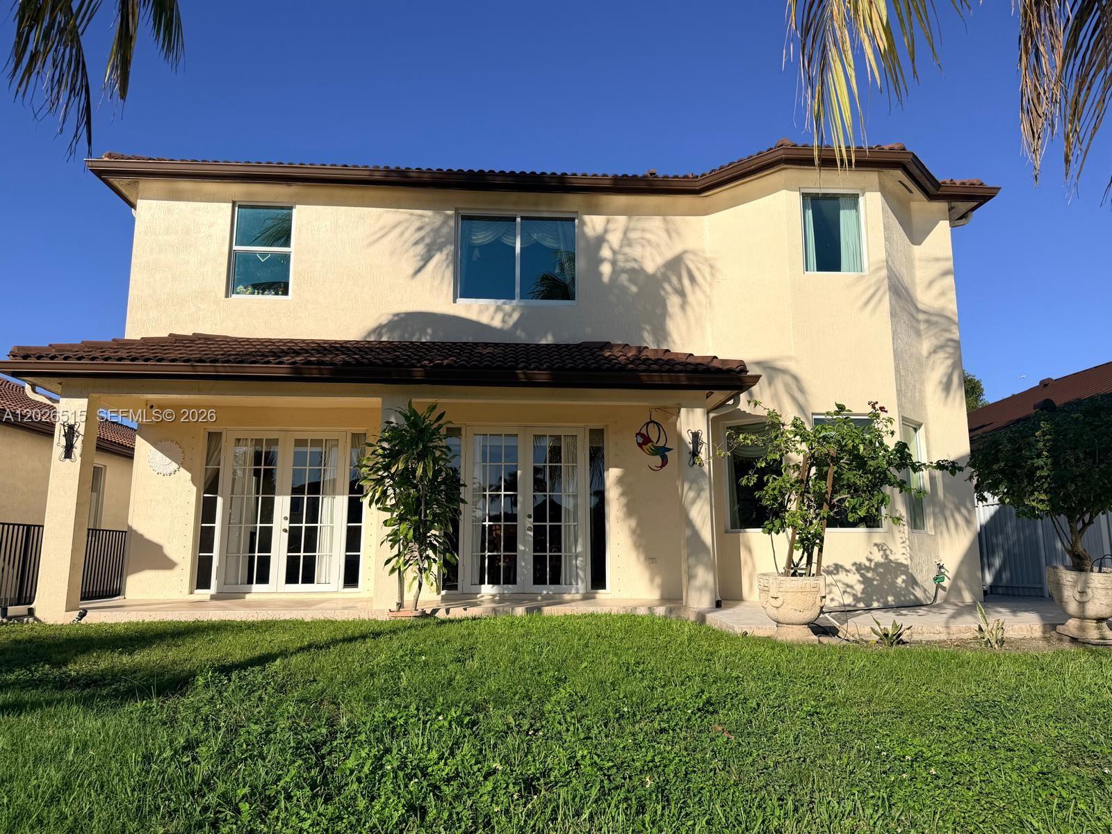 1065 Southwest 150th Place Miami, FL 33194 - Photo 12 of 14 a front view of a house with a yard