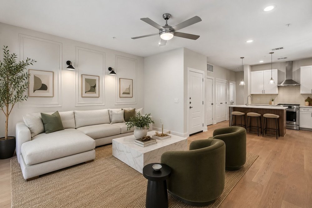 2827 Manor Road, Unit 2201 Austin, TX 78722 - Photo 3 of 40 Open-concept living space featuring wood-finish flooring, a contemporary kitchen island with seating, a ceiling fan with integrated lighting, recessed lighting, and wall paneling