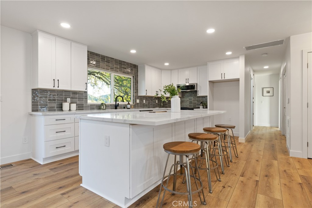 4150 Lobos Avenue Atascadero, CA 93422 - Photo 21 of 59 a kitchen with stainless steel appliances kitchen island granite countertop a table chairs refrigerator and sink