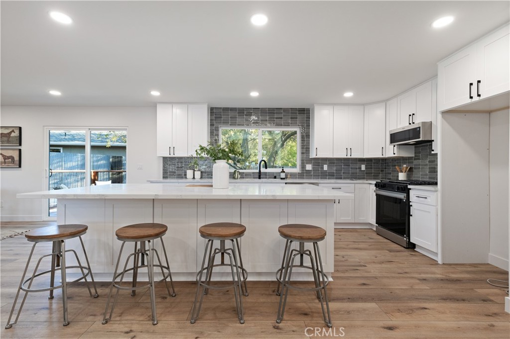 4150 Lobos Avenue Atascadero, CA 93422 - Photo 22 of 59 a kitchen with granite countertop white cabinets and chairs