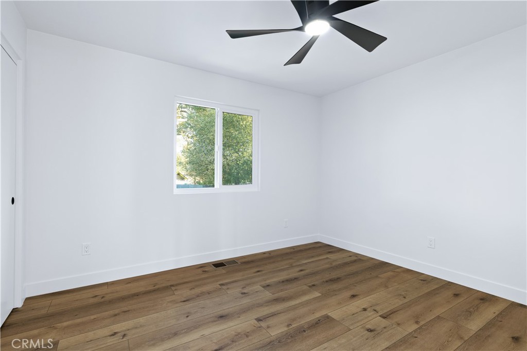 4150 Lobos Avenue Atascadero, CA 93422 - Photo 32 of 59 an empty room with wooden floor ceiling fan and windows