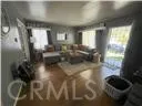 a living room with stainless steel appliances furniture a rug and a view of kitchen