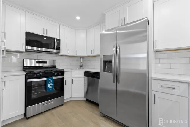 a kitchen with stainless steel appliances granite countertop a refrigerator and a stove top oven