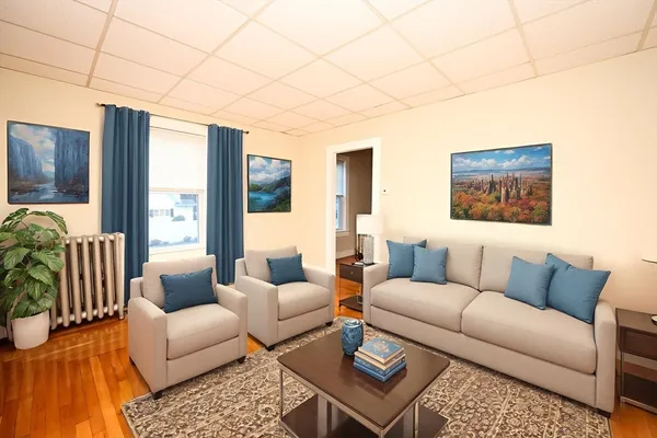 a living room with furniture a flat screen tv and a large window