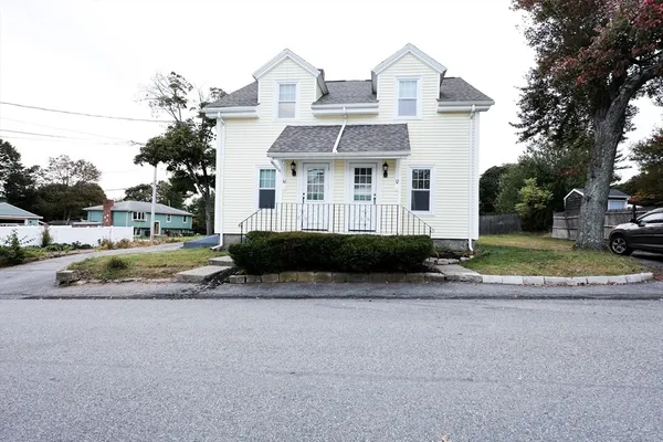 a view of a house with a yard and large trees