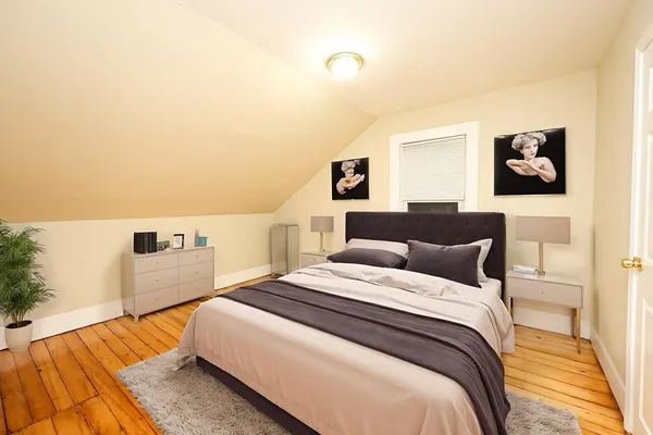 a bedroom with a bed and a painting on the wall