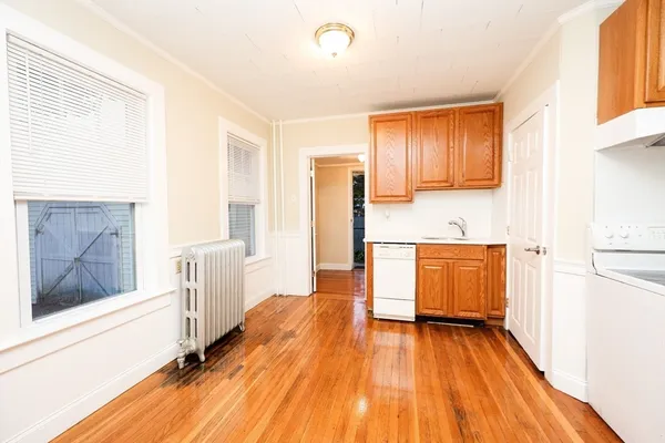 a kitchen with wooden floors and wooden cabinets