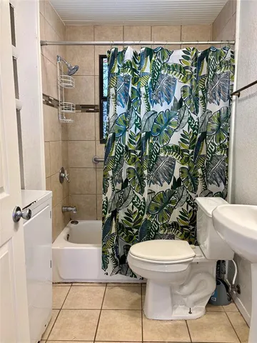 a white toilet sitting next to a bath tub and shower