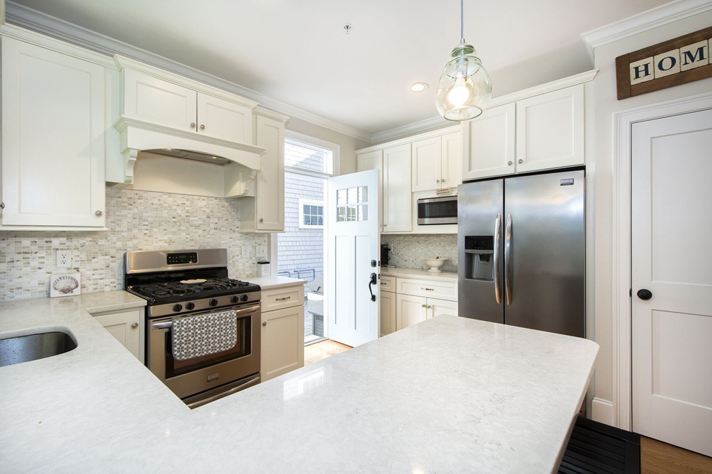 95 First Parish Road, Unit 2 Scituate, MA 02066 - Photo 3 of 19 a kitchen with a stove a refrigerator and a sink