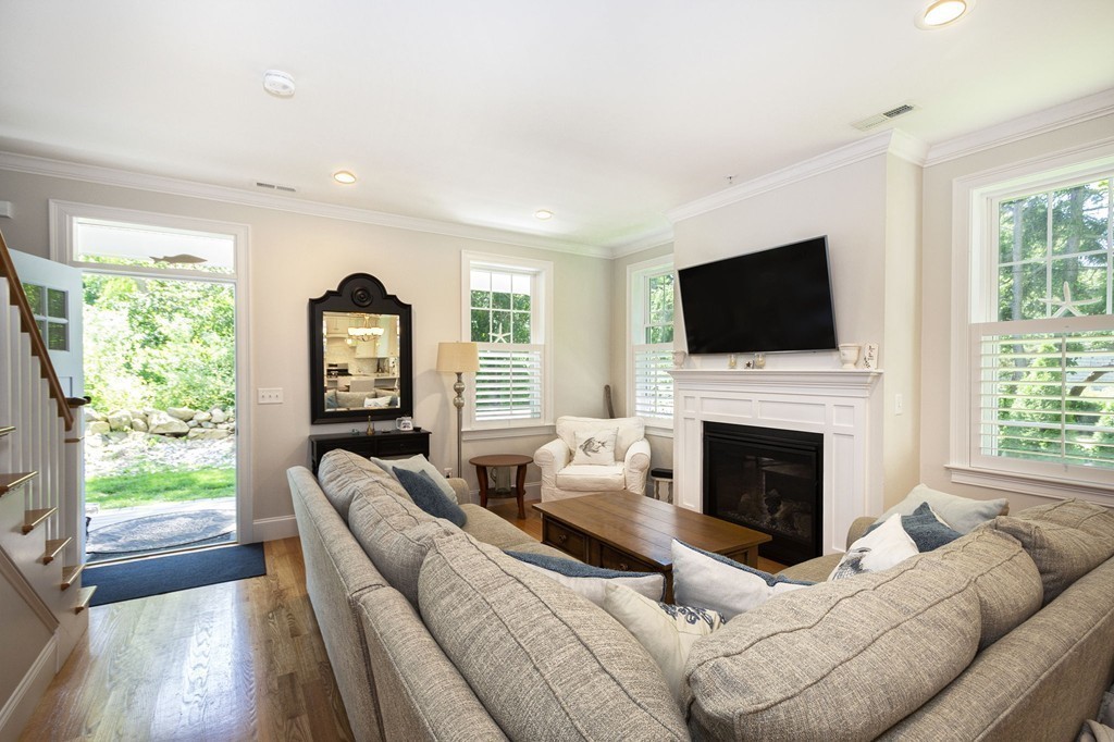 95 First Parish Road, Unit 2 Scituate, MA 02066 - Photo 8 of 19 a living room with furniture a fireplace and a flat screen tv