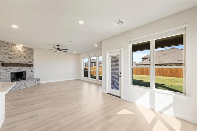 a view of an empty room with a fireplace and a window