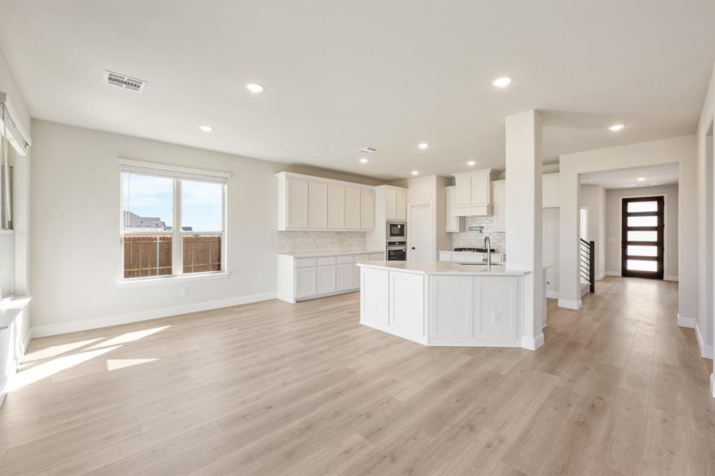 2000 Hickory Chase Lane Anna, TX 75409 - Photo 13 of 40 a view of a kitchen with kitchen island wooden floors appliances and a window