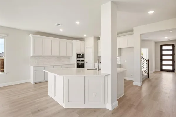 a kitchen with white cabinets and refrigerator