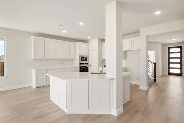 a kitchen with white cabinets and refrigerator