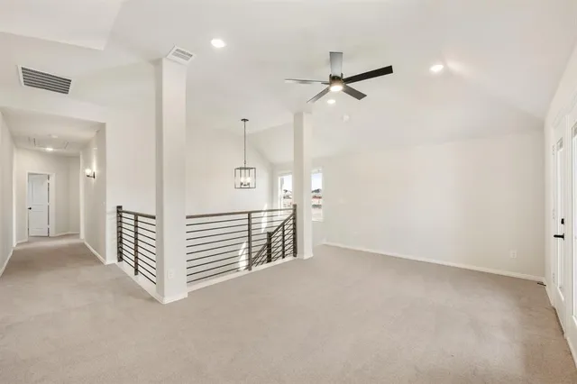 an empty room with a ceiling fan & entryway